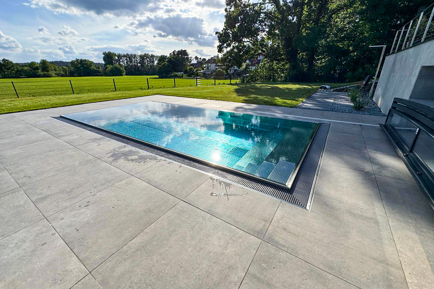 Edelstahlbecken mit Überlaufrinne, Treppe und freiem Blick in die Landschaft
