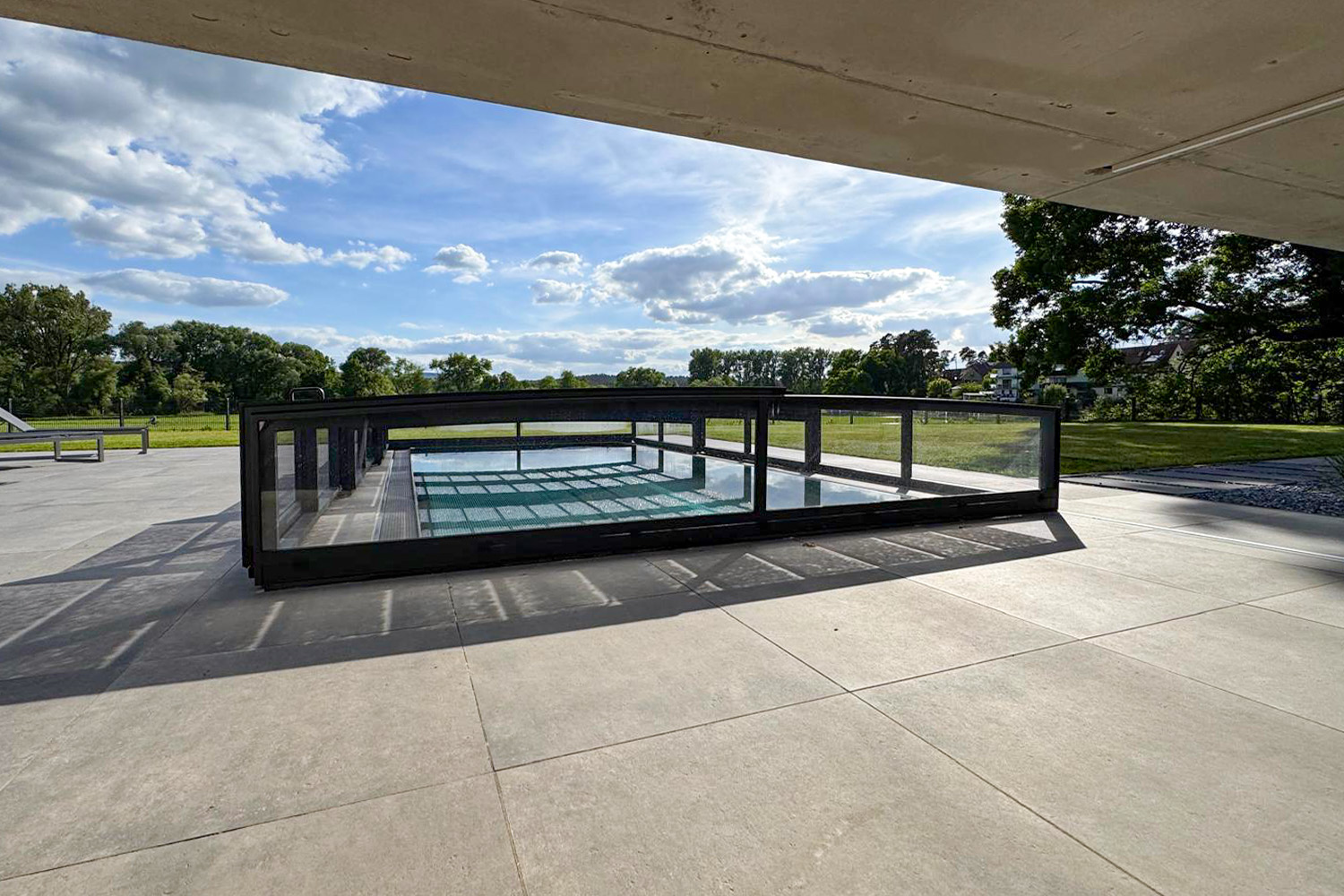 Superflache Poolüberdachung über einem Edelstahlpool mit klarer Linienführung