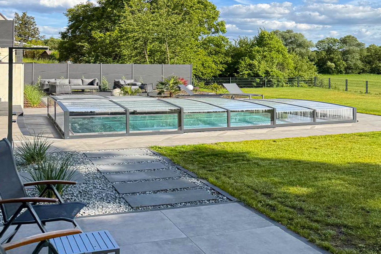 Edelstahlpool mit flacher Poolüberdachung Aluna NERO EASY R1 in moderner Gartengestaltung